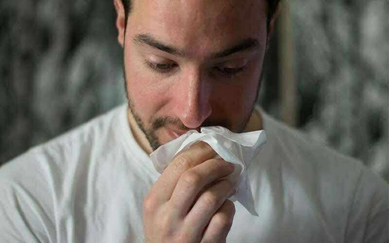 Mann benutzt Taschentuch